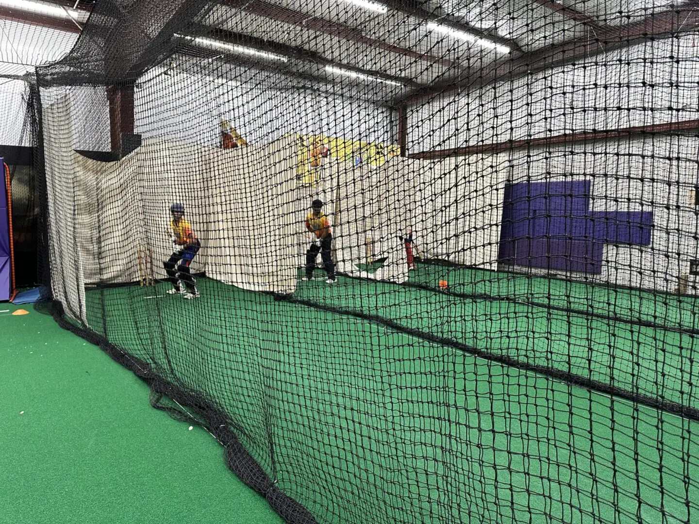 Indoor facility with green indoor turf and youth batting